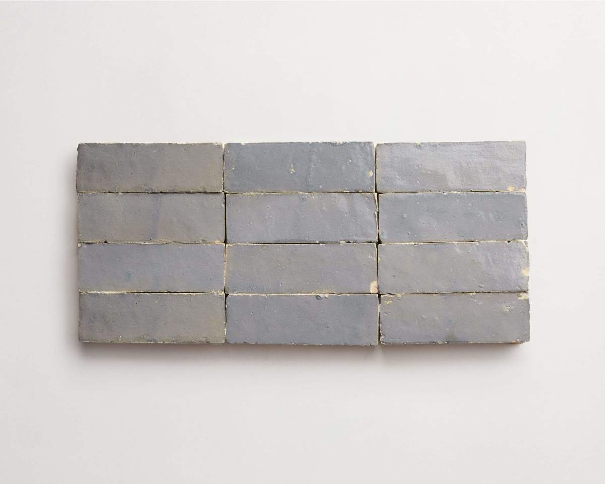 Eight rectangular gray bricks are arranged in two horizontal rows of four on a plain white background.