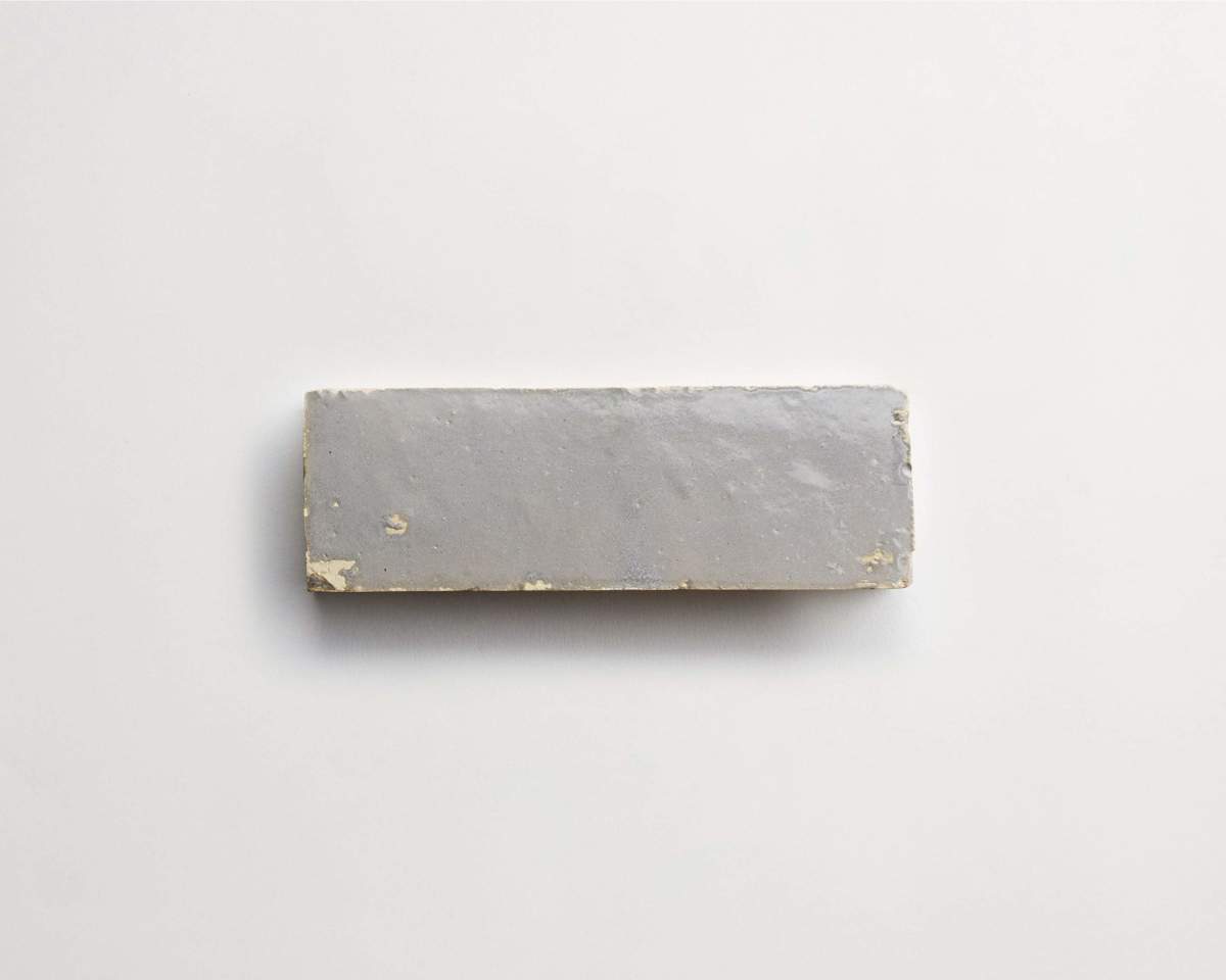 A rectangular gray brick with a slightly rough surface is placed on a plain white background.