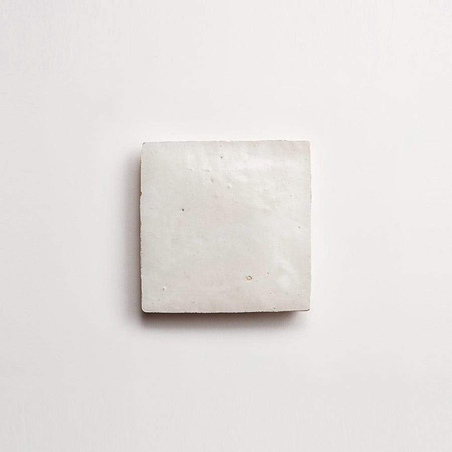 A single rectangular white tile with a slightly textured surface is placed on a plain white background.