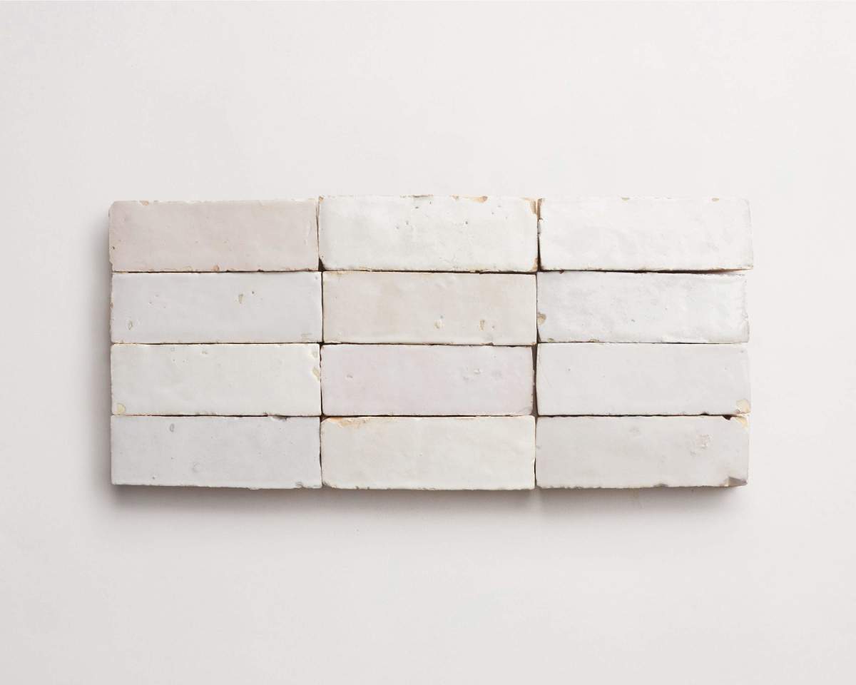 Twelve rectangular white bricks arranged in three rows of four on a plain white background.