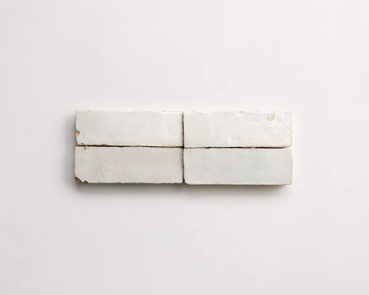 Four rectangular, off-white ceramic tiles are arranged in two rows on a plain white background.
