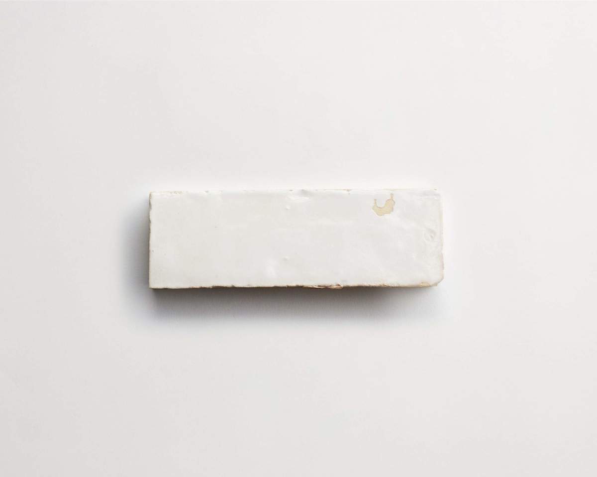A rectangular white bar with a small chipped area on an all-white background.