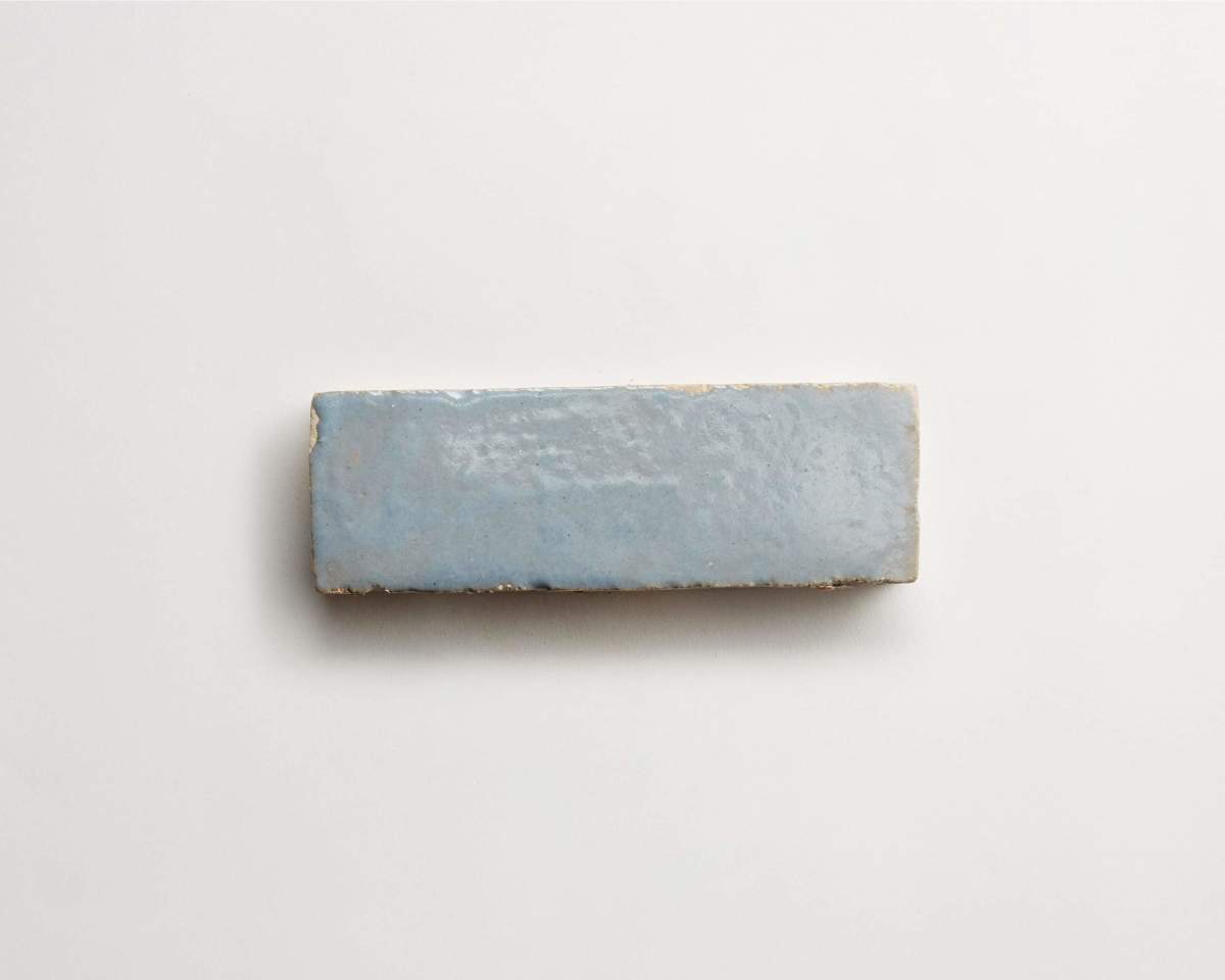 A single rectangular, light blue ceramic tile with a glossy finish, isolated on a plain white background.
