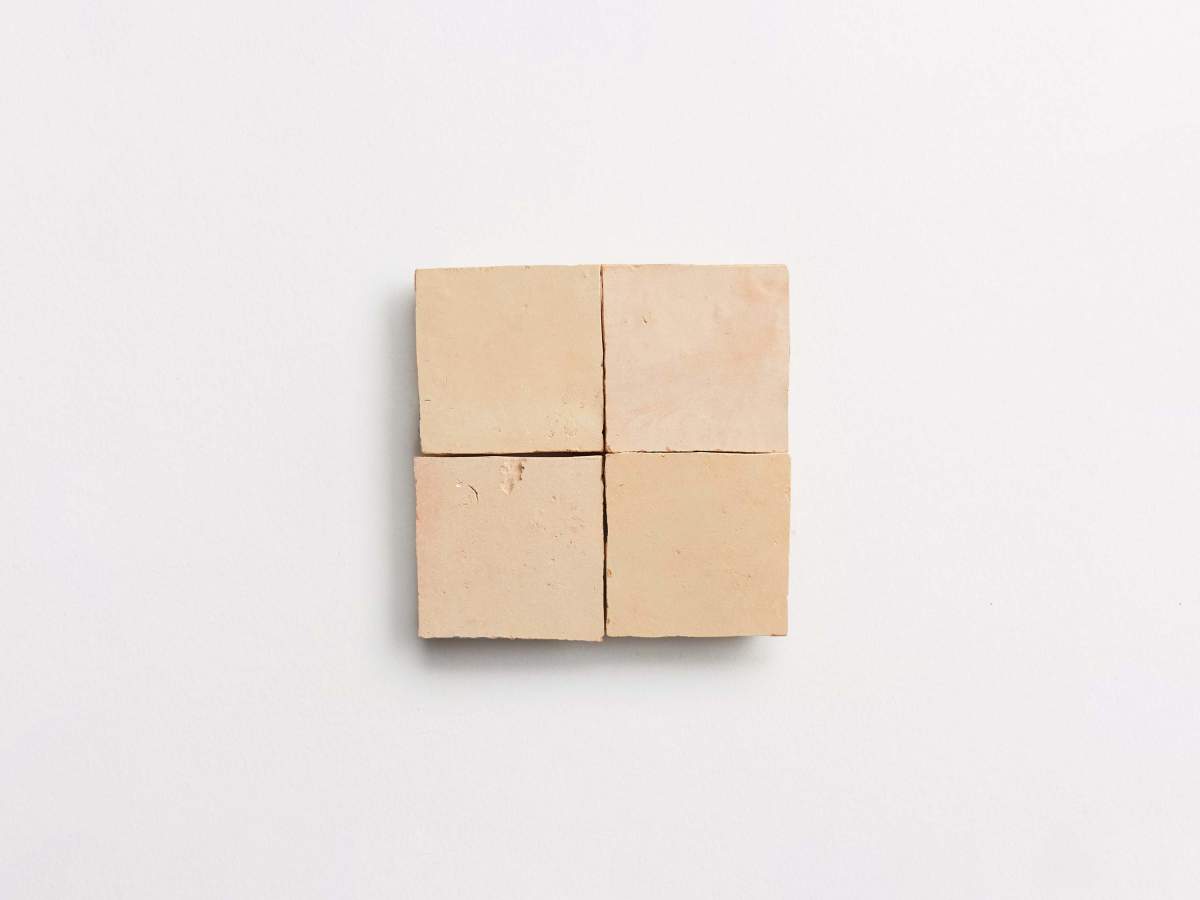Four beige square tiles arranged in a two-by-two grid on a plain white background.