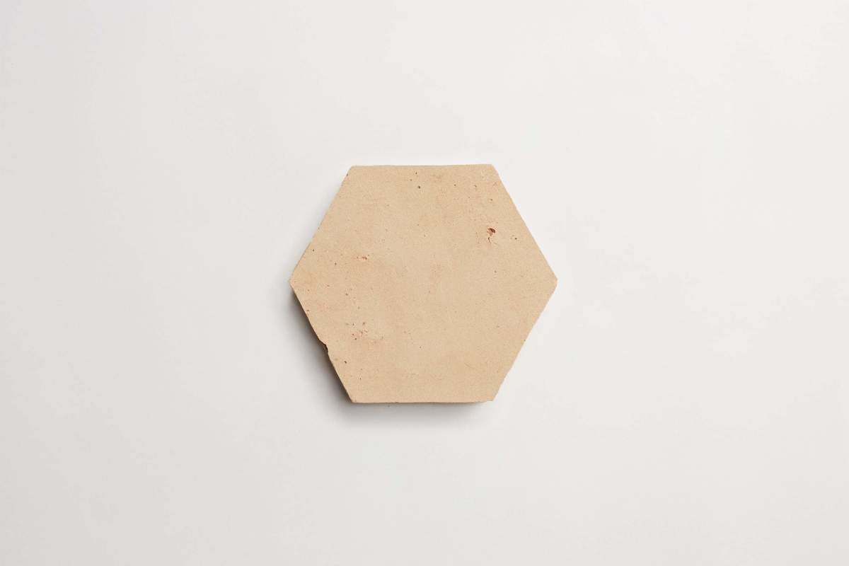 A plain, beige hexagonal tile placed on a white background.
