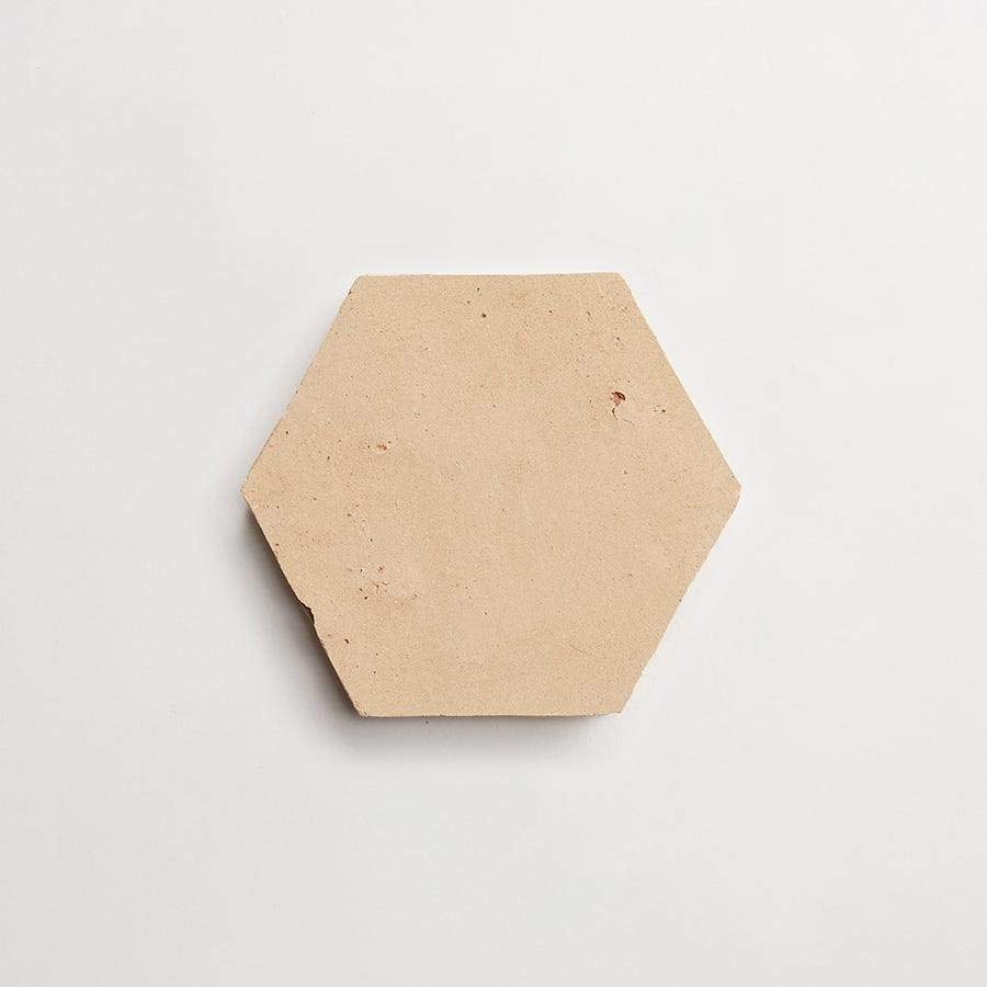 A plain, beige, hexagonal tile with a slightly rough surface is centered on a white background.