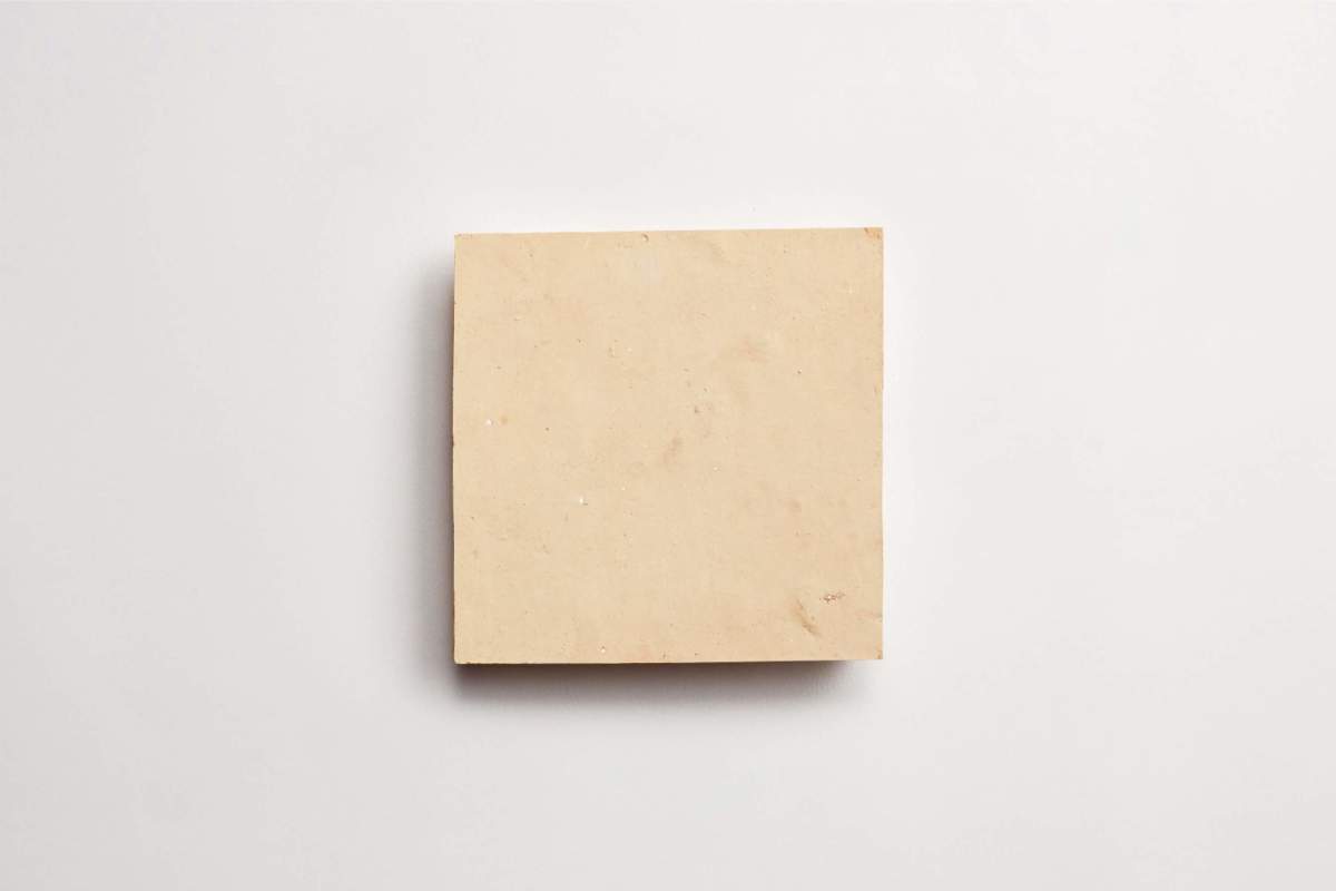 A plain, square beige tile placed on a white background.