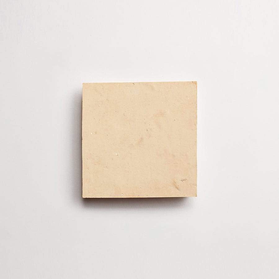 A plain, square beige tile is centered on a white background.