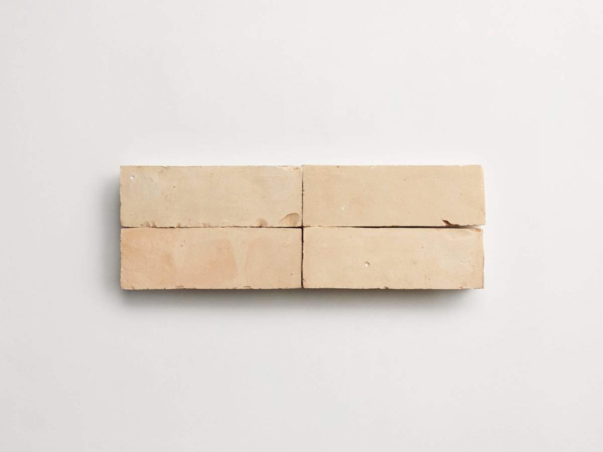 Four rectangular beige bricks are arranged side by side in two rows against a plain white background.