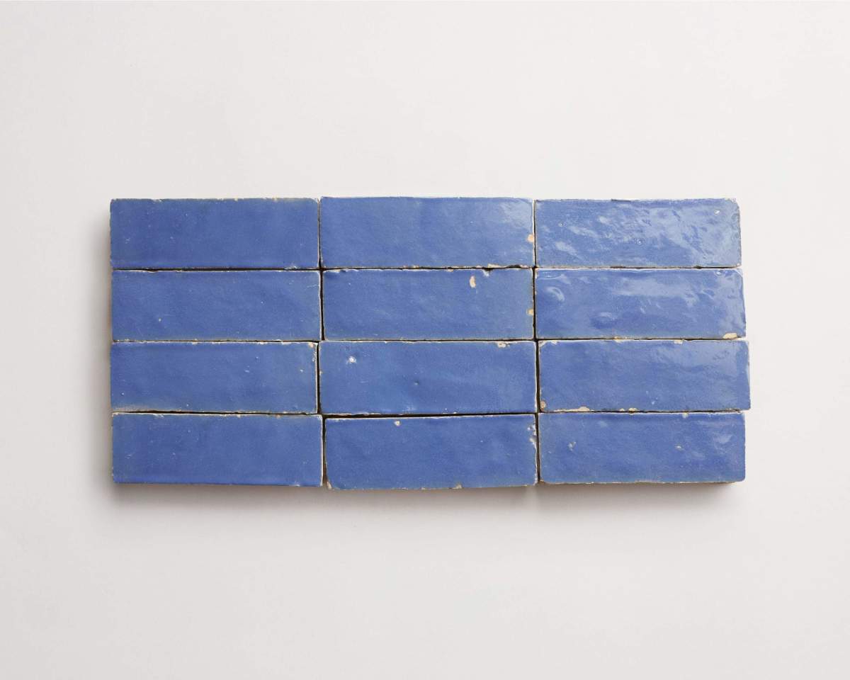 Ten rectangular blue ceramic tiles are arranged in two rows of five on a white background.