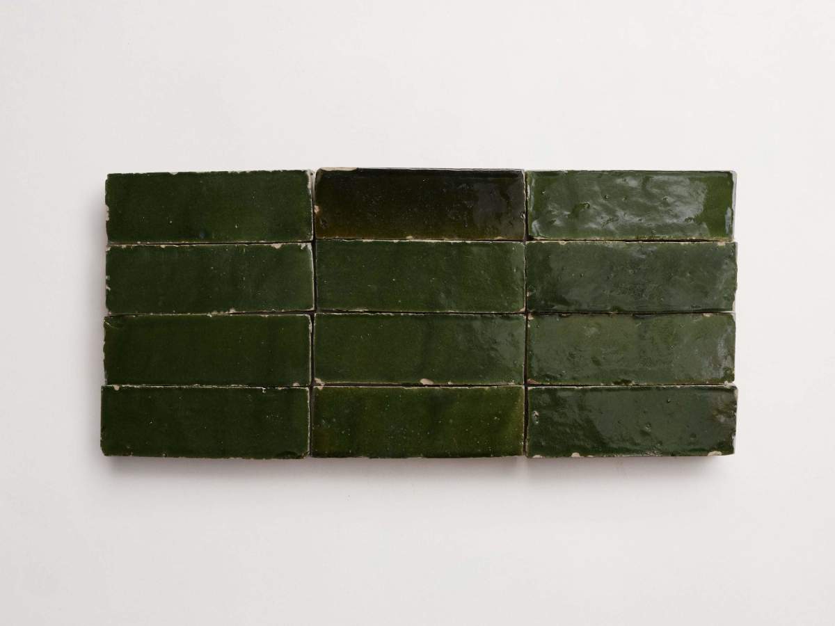 Twelve rectangular, glossy dark green tiles are arranged in two rows of six on a plain white background.