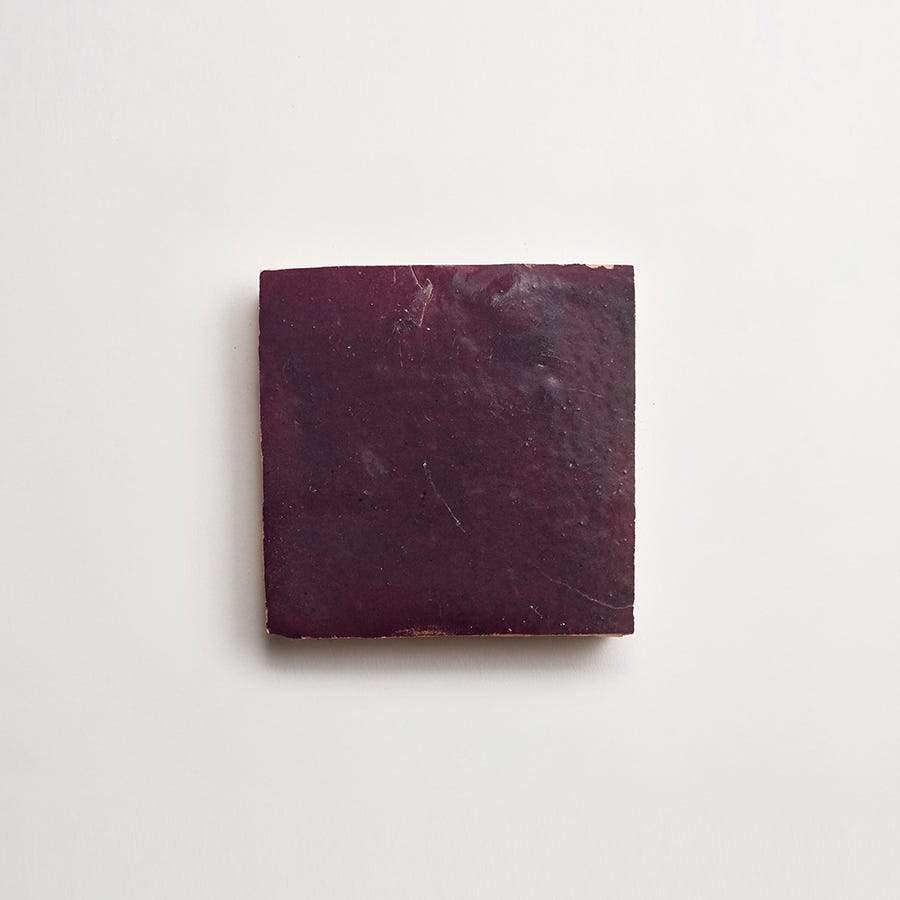 A single dark purple square tile centered on a plain white background.