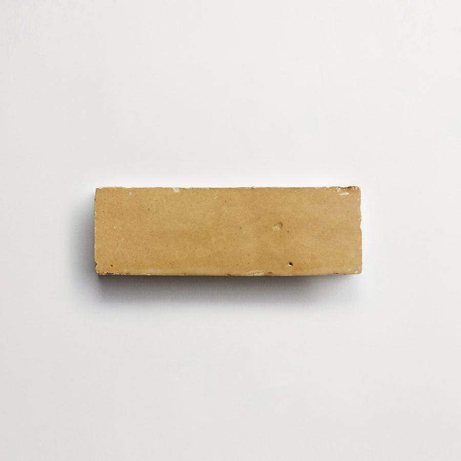 A single rectangular light brown brick placed on a plain white background.