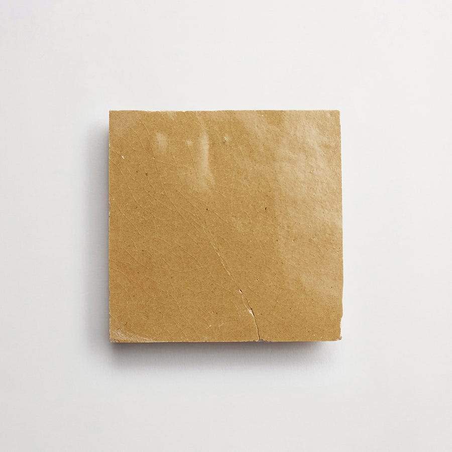 A square piece of plain brown cardboard with visible creases, placed on a white background.