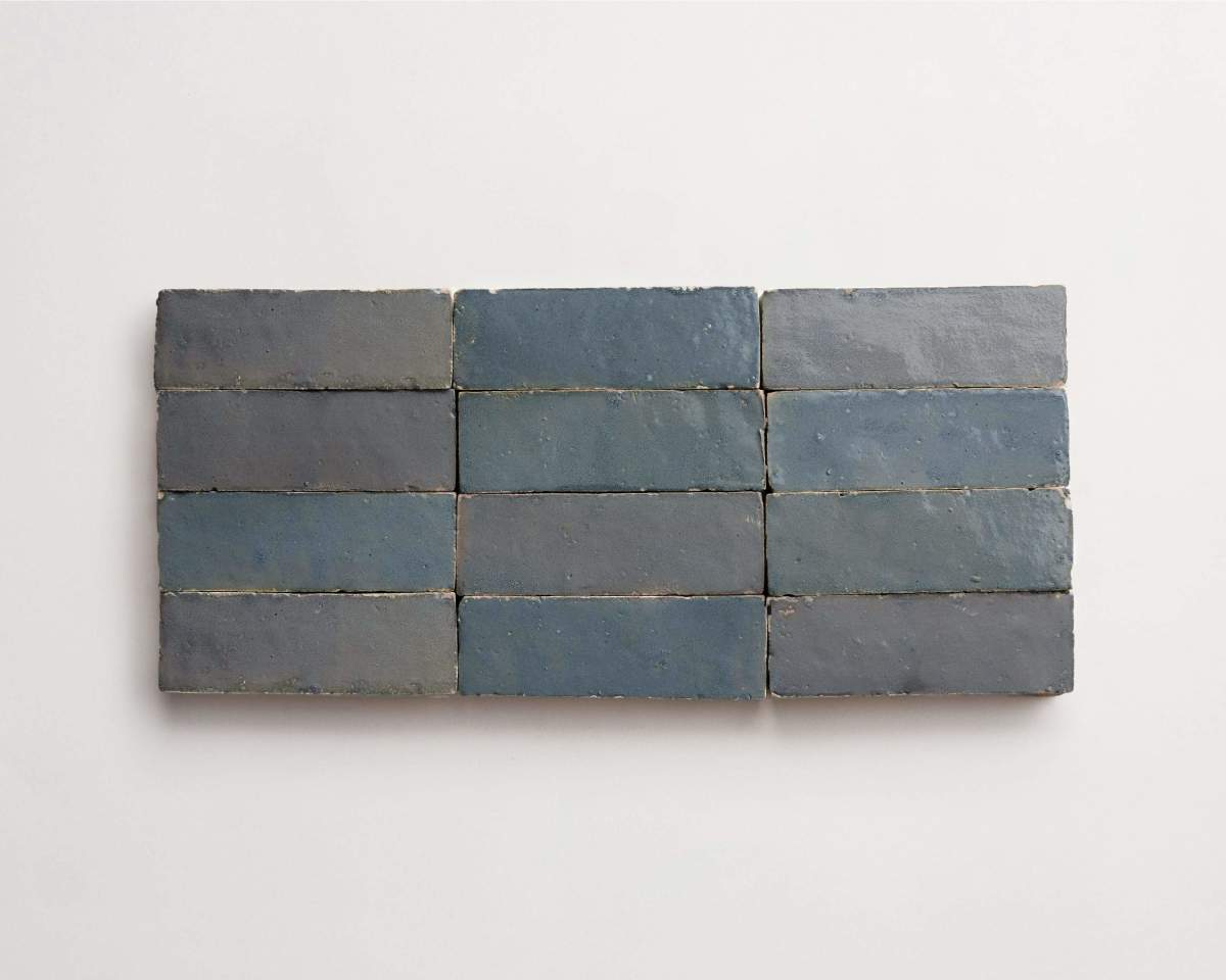 Eight rectangular blue-gray bricks are arranged in two horizontal rows of four on a plain white background.