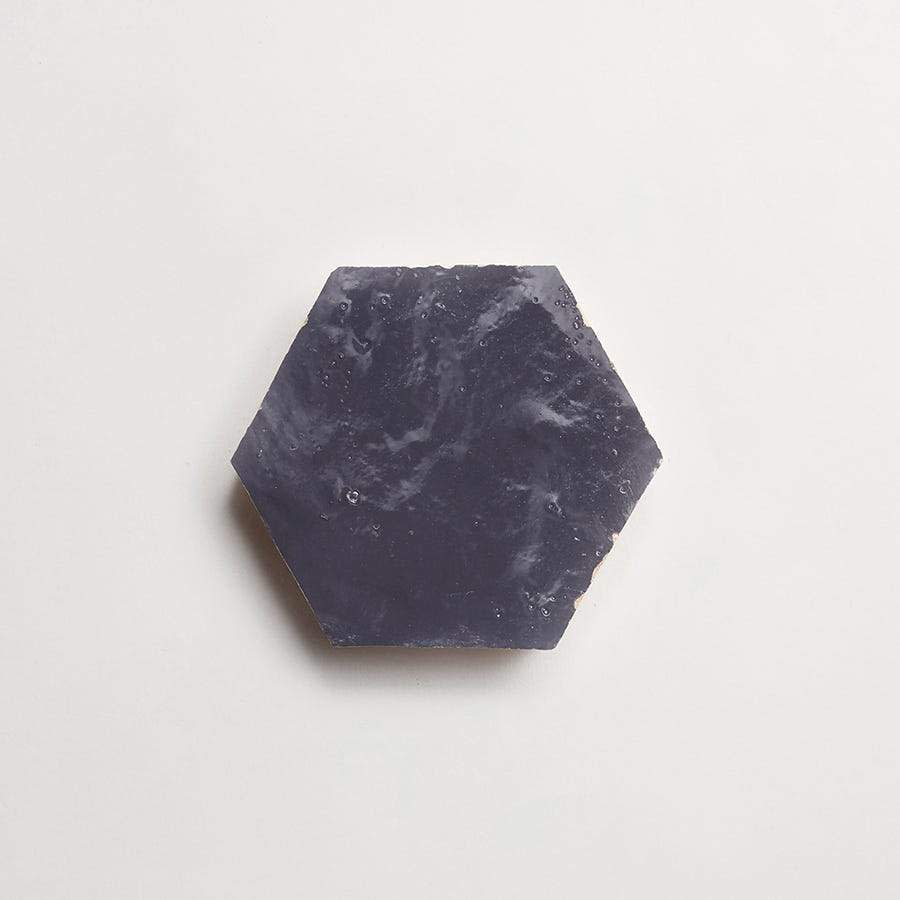 A dark purple, hexagonal bar of soap on a plain white background.