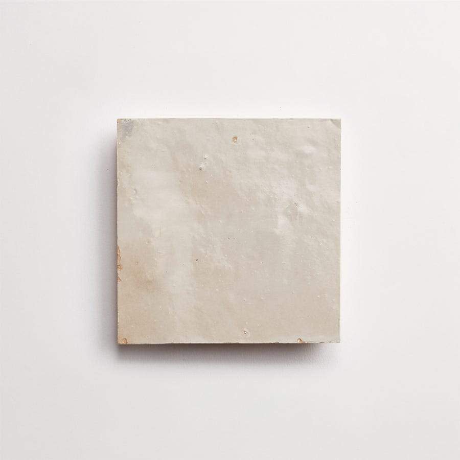 A single square beige tile with a slightly rough texture placed on a plain white background.