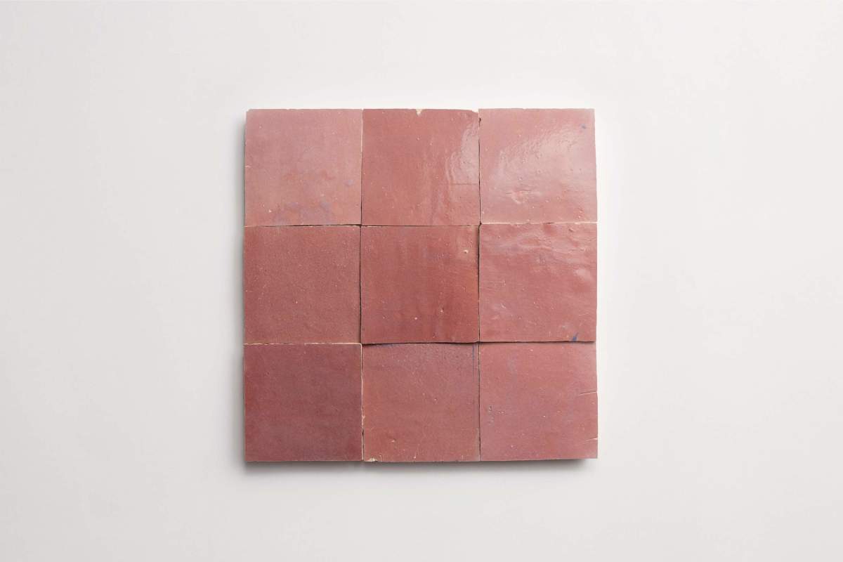 Nine square pieces of reddish-brown tile arranged in a three-by-three grid on a white background.