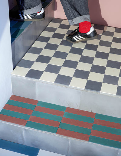 Checkered floor with a step and person wearing black shoes and red socks